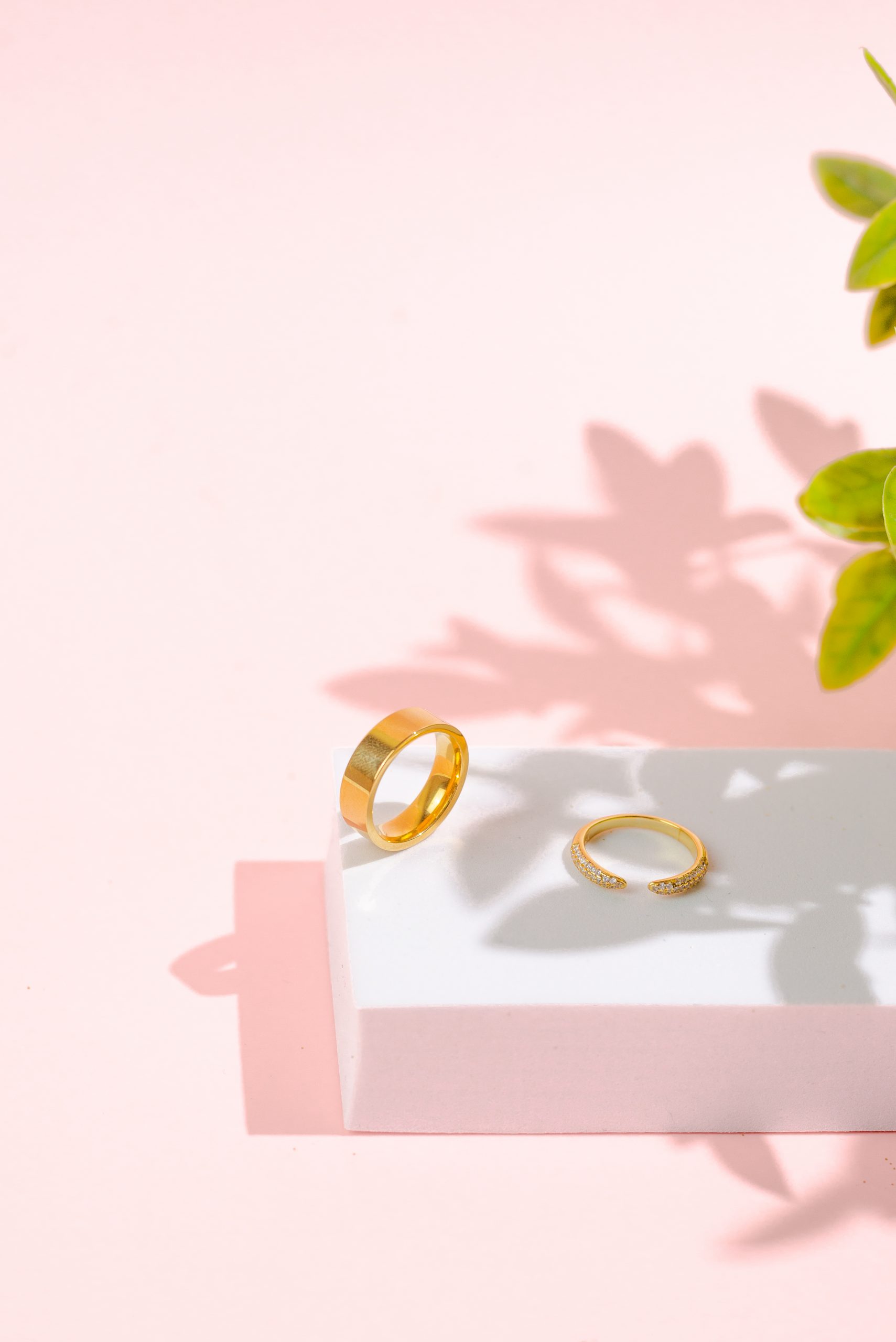 still like jewelery product photography services by danielle deangelis. gold rings photographed on a pink background with a white riser