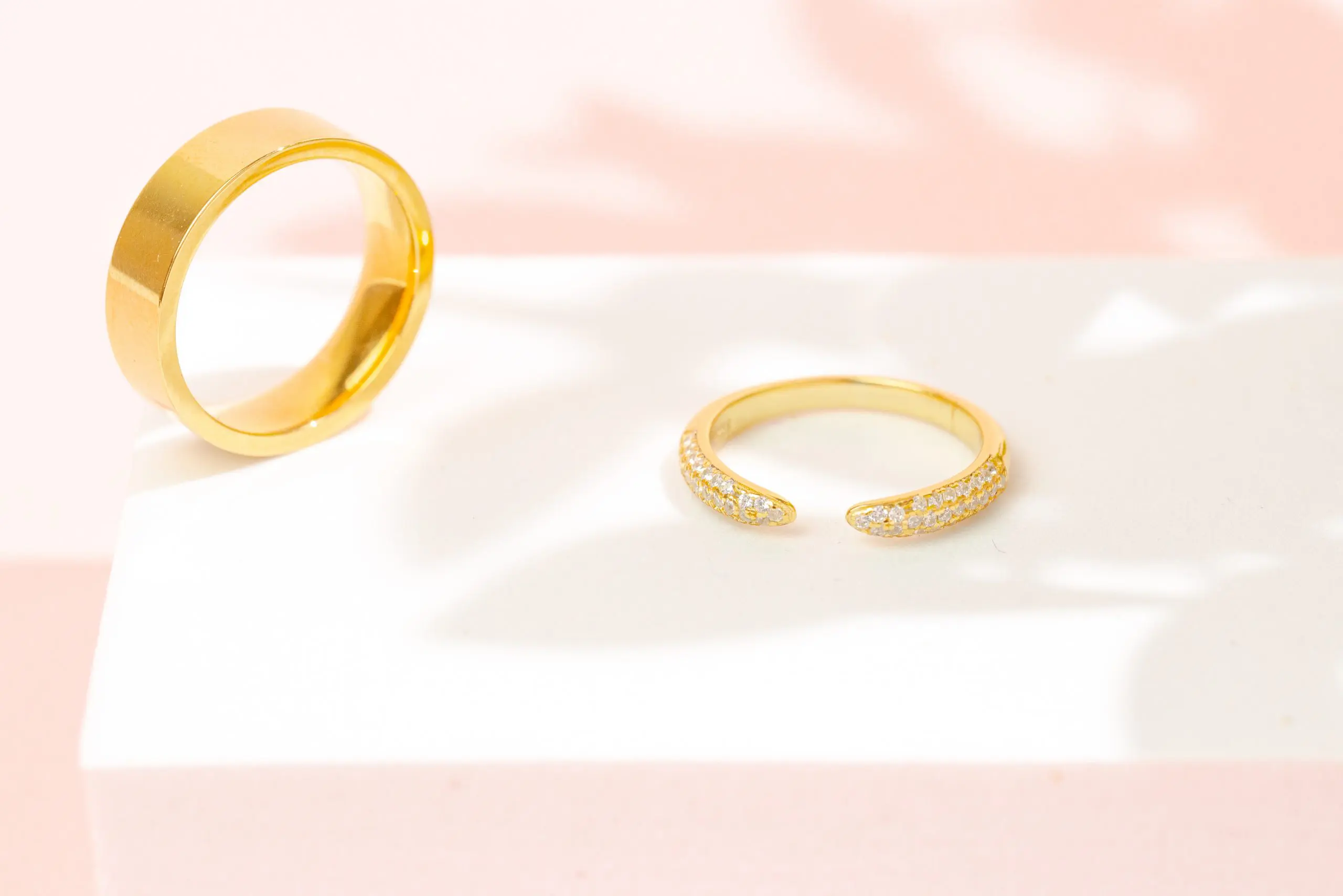 still like jewelery product photography services by danielle deangelis. gold rings photographed on a pink background with a white riser
