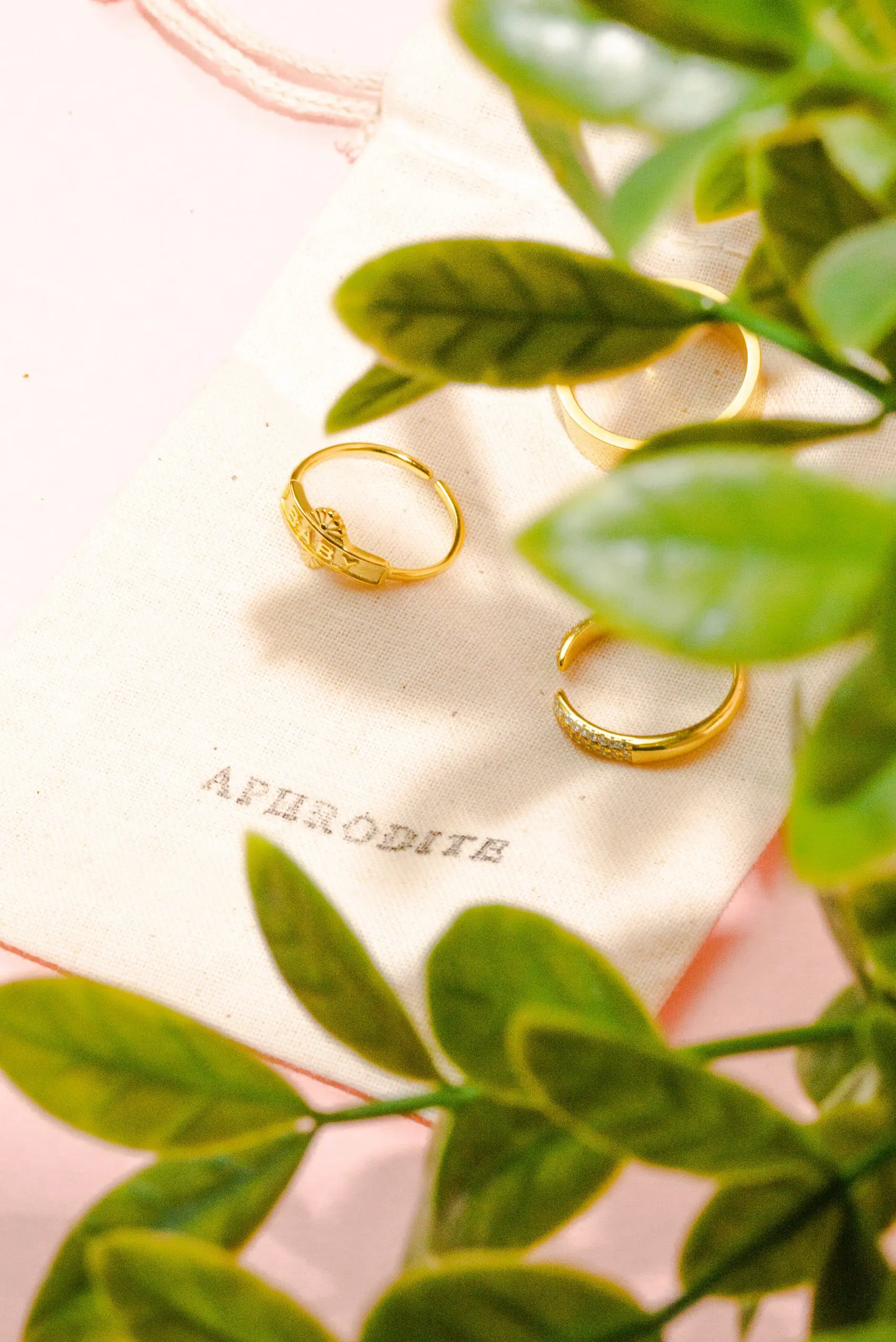 still like jewelery product photography services by danielle deangelis. gold rings photographed on a pink background with a white riser